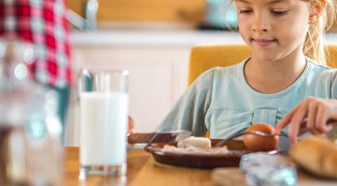 Young girl eating breakfast.