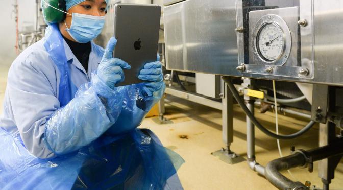 Employee using tablet to monitor equipment.