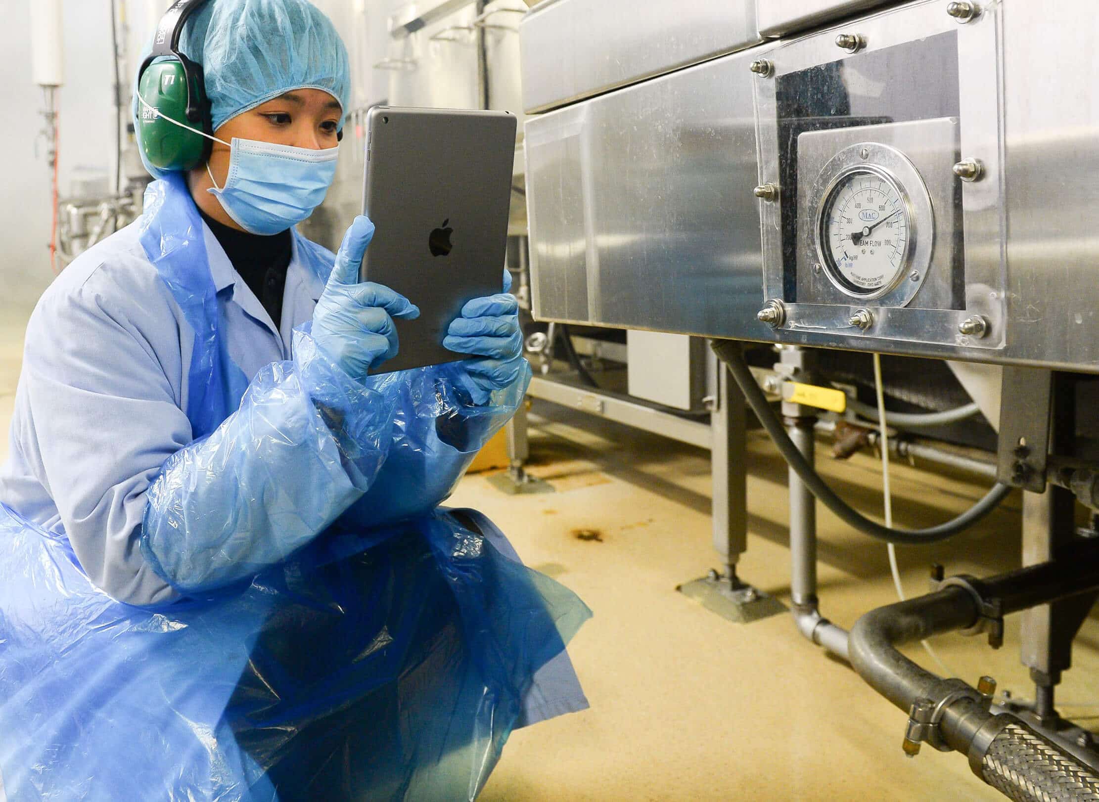 Employee using tablet to monitor equipment.