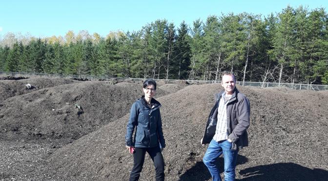 Man and woman standing in front of landfill