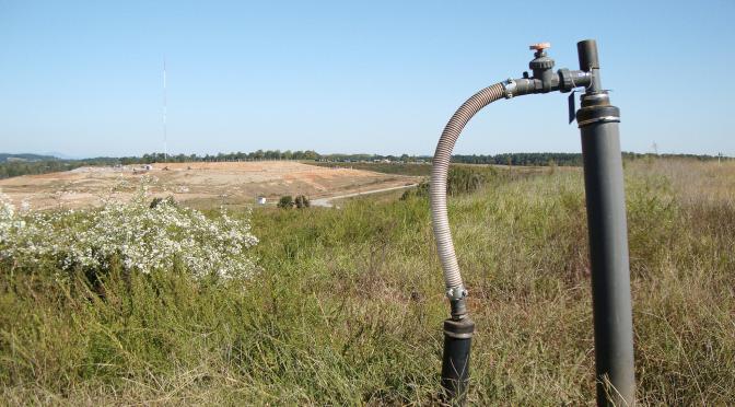 Gas pipe with large landfill in the background