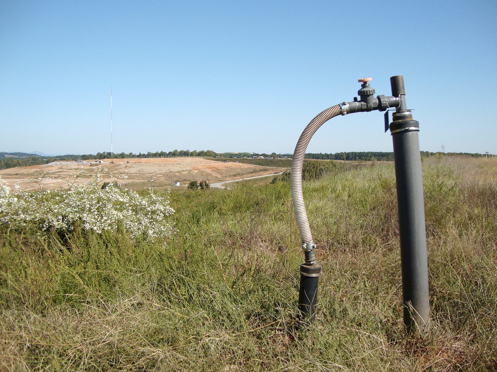 Gas pipe with large landfill in the background