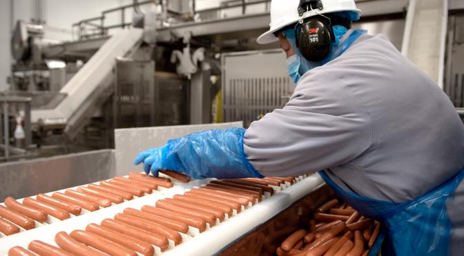 Employee working on wiener production line at Heritage plant.