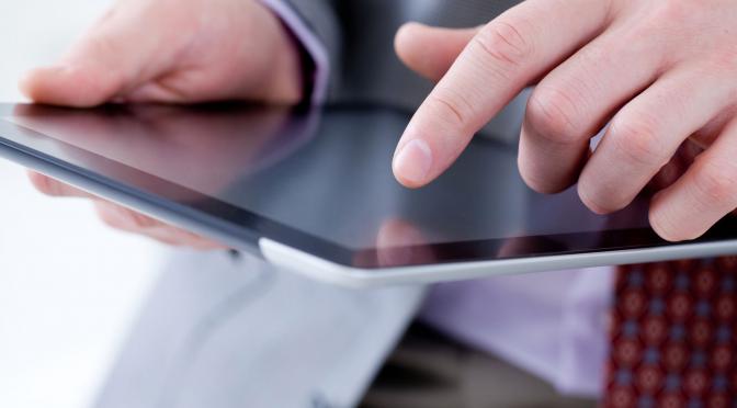 Closeup of man using a tablet.