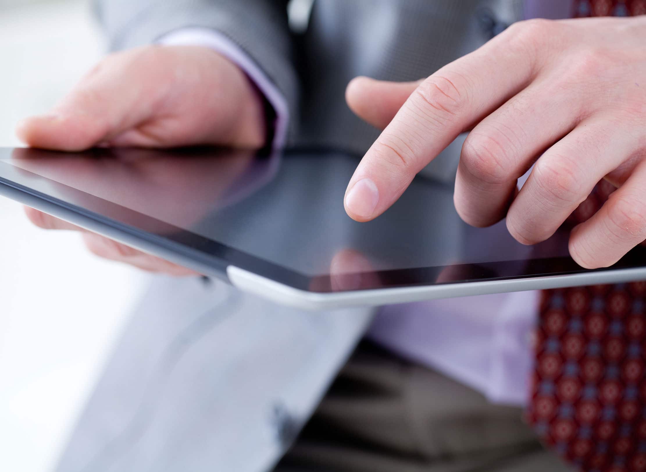 Closeup of man using a tablet.