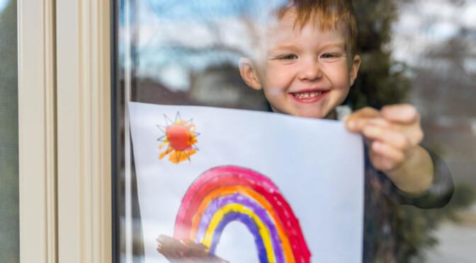 enfant souriant tenant un dessin