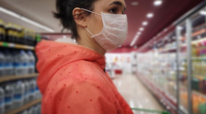 Woman in supermarket wearing a mask