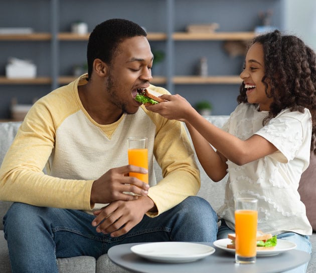 Père et fille mangeant