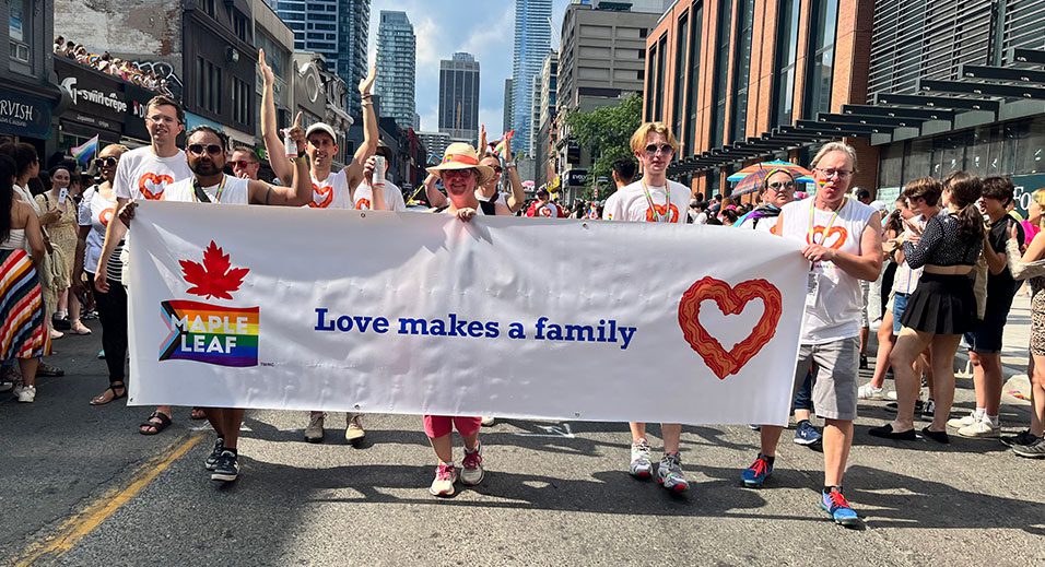 Les employés de Maple Leaf défilent avec la bannière Pride.