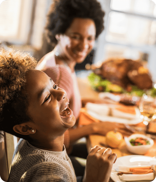 Enfant riant à la table du dîner