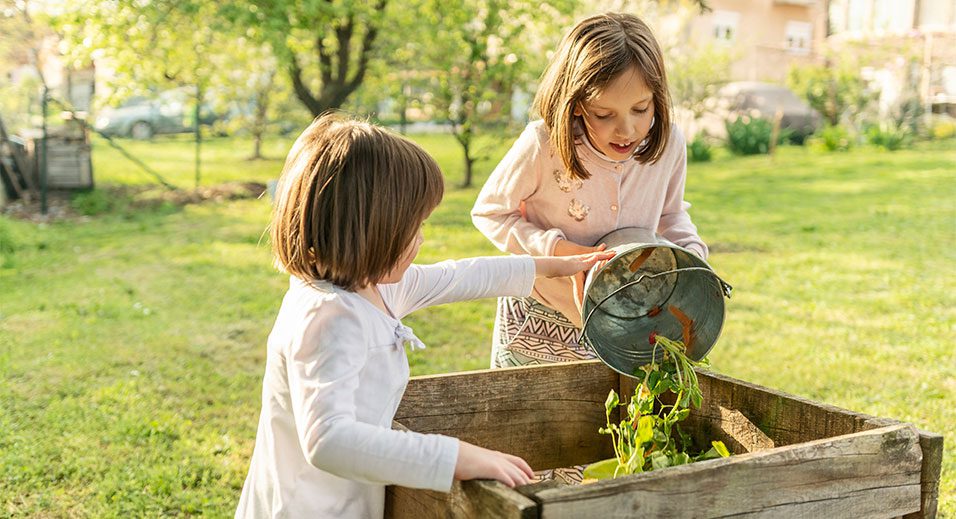 petites filles compostant ensemble dans le jardin