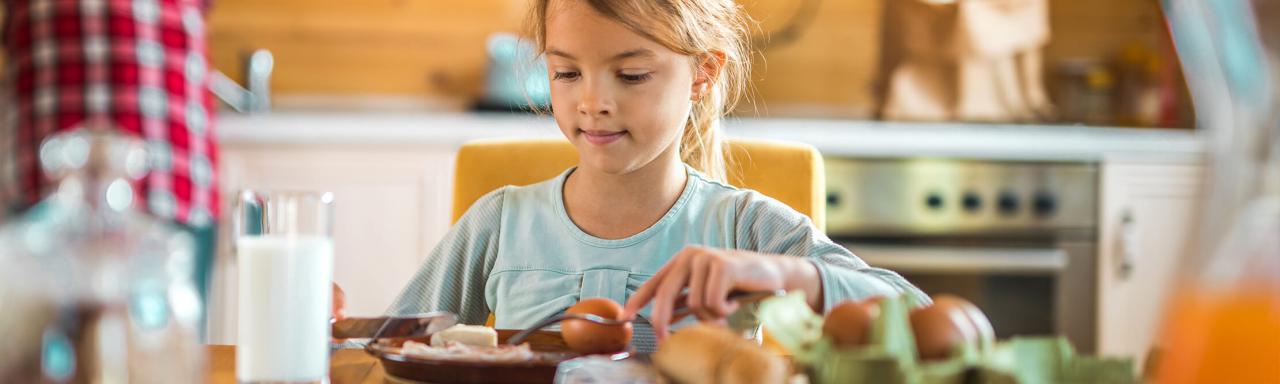 Young girl eating breakfast.