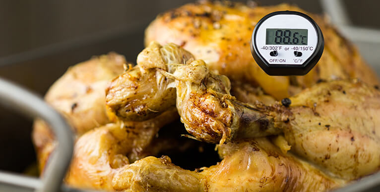 A roast chicken with a thermometer