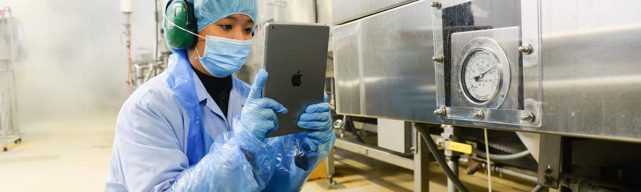 Employee using tablet to monitor equipment.