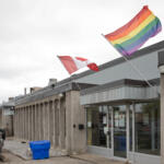 Canadian and Pride flags flying above the entrance to the Lepage facility in Toronto, Ontario