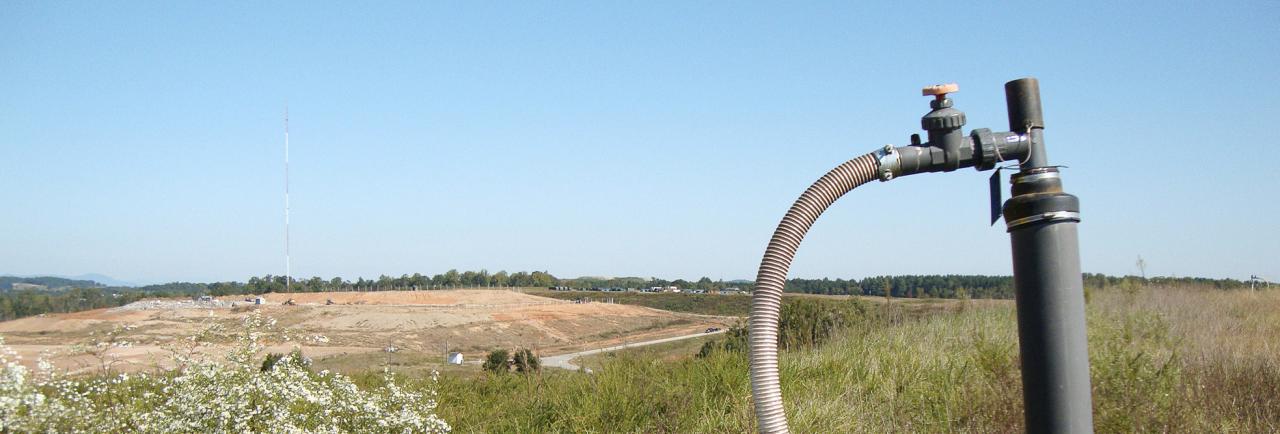 Gas pipe with large landfill in the background