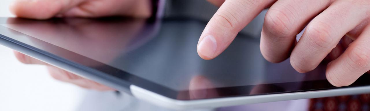 Closeup of man using a tablet.