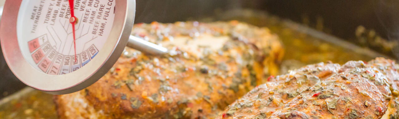 Checking chicken breast readiness with a meat thermometer