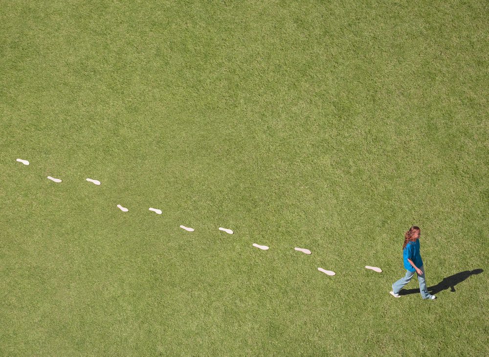 Girl walking with visible footprints behind her