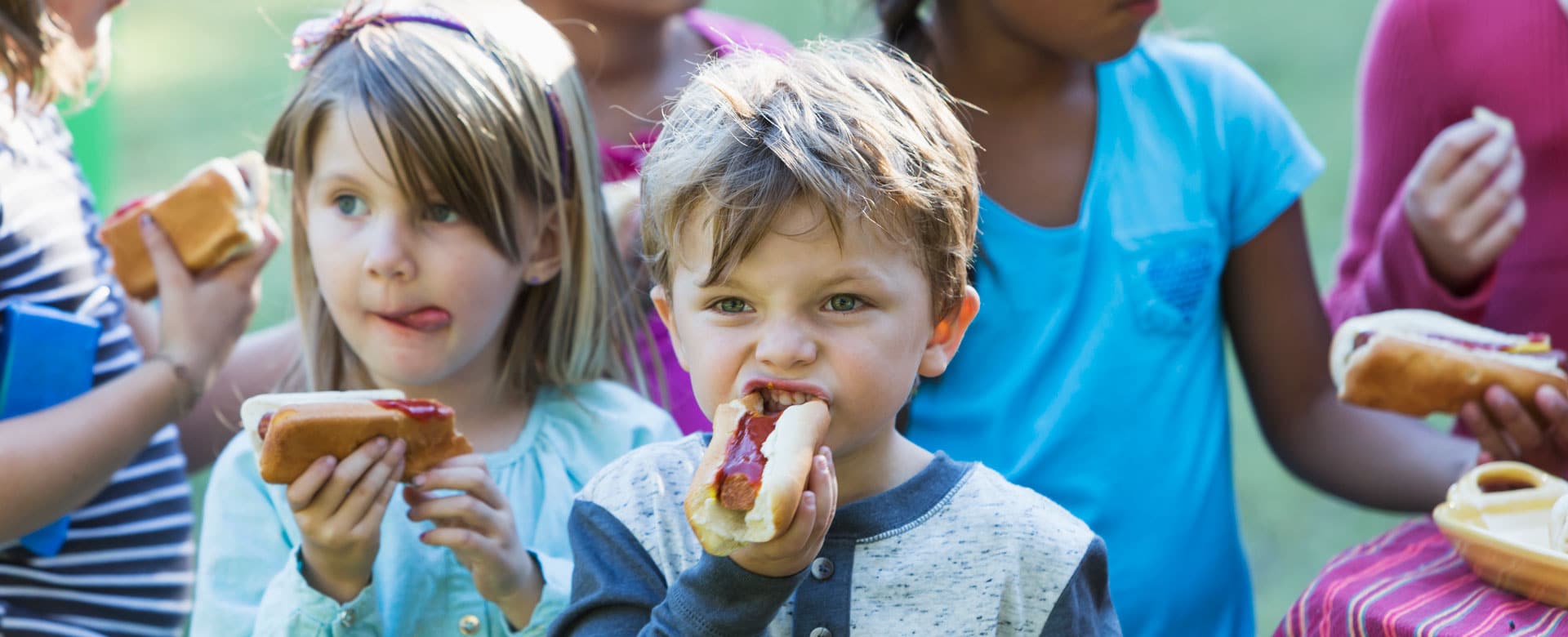 petits enfants mangeant des hot-dogs