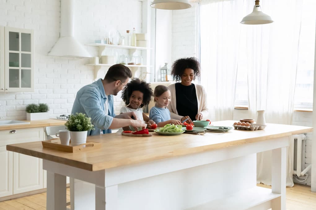 Family preparing food at kitchen counter