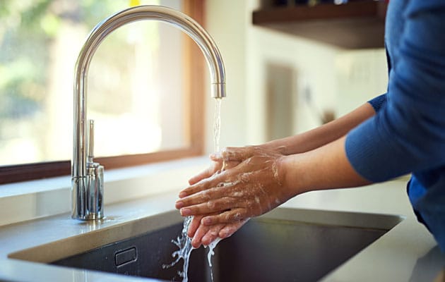 Washing hands in kitchen sink