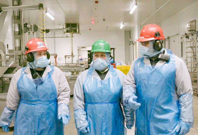 Supervisors on production floor wearing PPE