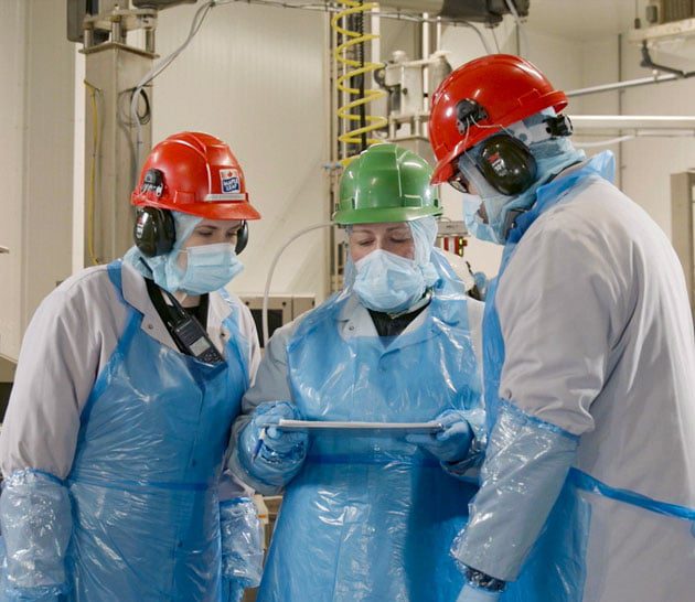 Supervisors on production floor wearing PPE