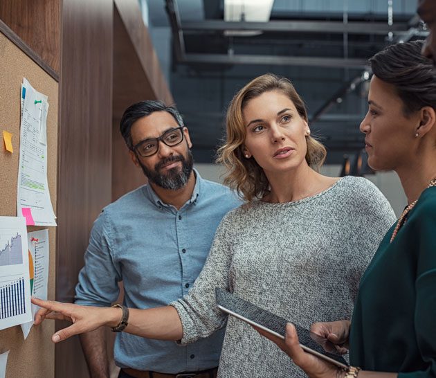 People discussing graphs on a board