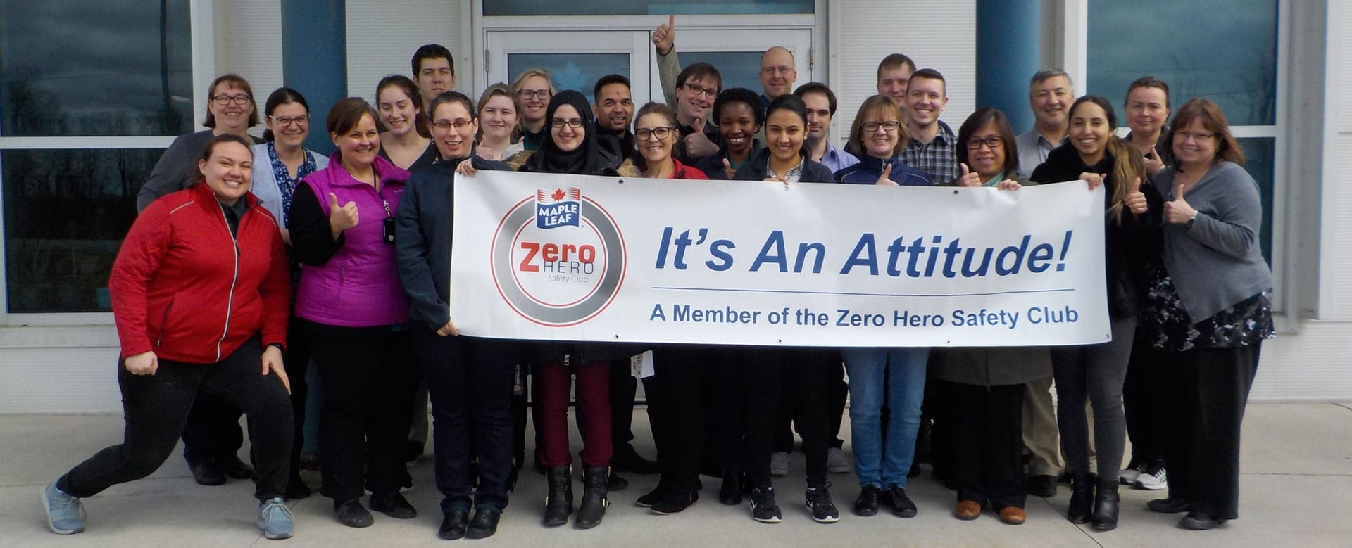 groupe de membres de l'équipe tenant le signe Zero Hero