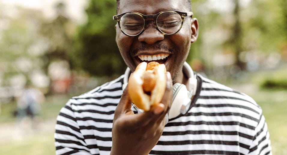 National Hot Dog Day - man biting into a hot dog